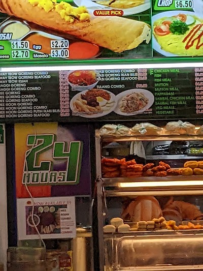 Al-Jalal By Habib's Rojak menu board featuring egg rolls ($1.50-$3.00), pork chop ($6.50), and various goreng combos with prices, plus display of fried food items. — Items: Egg Roll $1.50 · Masala $2.20 · Cheese $2.70 · Egg Roll Combo $3.00 · Pork Chop $6.50 · Biryani Goreng Combo $23.00 · Biryani Goreng Seafood $25.00 · Tulang Combo $23.00 · Fish Meal · Mutton Meal · Sambal Chicken Meal · Sambal Fish Meal