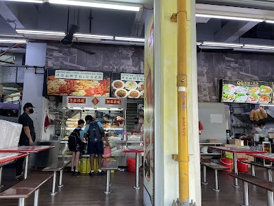 JustEat Nasi Lemak and Economic Bee Hoon food stall in a hawker center with menu boards displaying fried items and Asian noodle dishes — Items: Nasi Lemak · Economic Bee Hoon · Fried items (appears to be spring rolls or similar)
