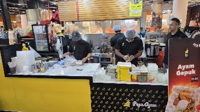 Papa Ayam restaurant counter showing staff preparing Ayam Gepuk (fried chicken) priced at $9.60 with kitchen setup and signage visible. — Items: Ayam Gepuk $9.60