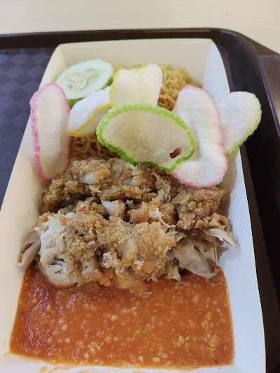 Papa Ayam fried chicken dish with crispy coating, noodles, cucumber, pickled radish, egg, and sauce in white container. — Items: Fried Chicken with Crispy Coating · Noodles · Cucumber Slices · Pickled Radish · Hard Boiled Egg · Sauce/Gravy