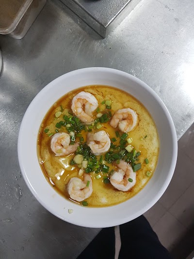 Shrimp Curry Noodle Soup from San Gu Cuisine featuring tender shrimp, green onions, and creamy yellow curry broth in a white bowl. — Items: Shrimp Curry Noodle Soup