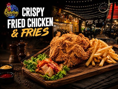 Chickyfish crispy fried chicken and fries served on wooden board with lettuce and sauce, restaurant storefront background. — Items: Crispy Fried Chicken · Fries