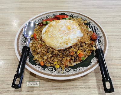 Nasi Goreng from Srisun Prata featuring fried rice with vegetables topped with a fried egg, served on a decorative plate with black chopsticks. — Items: Nasi Goreng