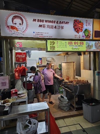 M BBQ Wings & Satay storefront showing grilled skewered meat satay and BBQ chicken wings with menu prices starting from $0.90 for satay items and $10 for combo platters. — Items: BBQ Wings $10 · Satay $10 · Pork Satay $0.90 · Chicken Satay $0.90 · Mutton Satay $0.90 · Ketupat $0.90