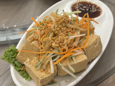 Crispy Tofu Wraps from Yes Natural Restaurant served with julienned carrots, cucumber, scallions, and dark dipping sauce on a white plate with lettuce. — Items: Crispy Tofu Wraps