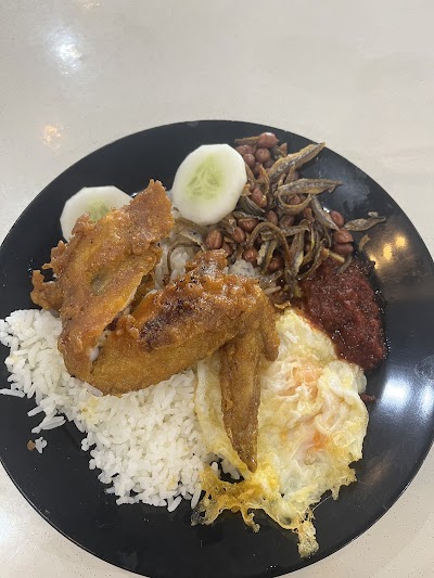 Haryati's Malaysian plate featuring fried chicken, white rice, fried egg, boiled egg, dried anchovies, and beef rendang on black plate. — Items: Fried Chicken · White Rice · Fried Egg · Boiled Egg · Dried Anchovies (Ikan Bilis) · Beef Rendang