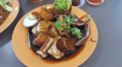 Cheok Kee Duck Rice dish featuring braised duck with beancurd, boiled egg, and vegetables in savory gravy on yellow plate — Items: Braised Duck with Beancurd (Tau Kwa) · Boiled Egg · Braised Vegetables