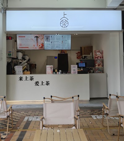 Shang Cha tea shop interior with menu boards displaying Peach Oolong and other beverages, featuring Chinese signage and modern minimalist design. — Items: Peach Oolong