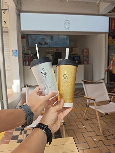 Two bubble tea drinks from Shang Cha 上茶 - a clear milk tea and a golden milk tea in branded cups with black lids and straws. — Items: Milk Tea (Light/Clear) · Milk Tea (Golden/Yellow)
