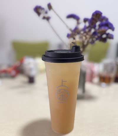 Shang Cha 上茶 branded tea drink in tall cup with black lid, appears to be oolong or milk tea beverage — Items: Tea Beverage (Oolong or Similar)