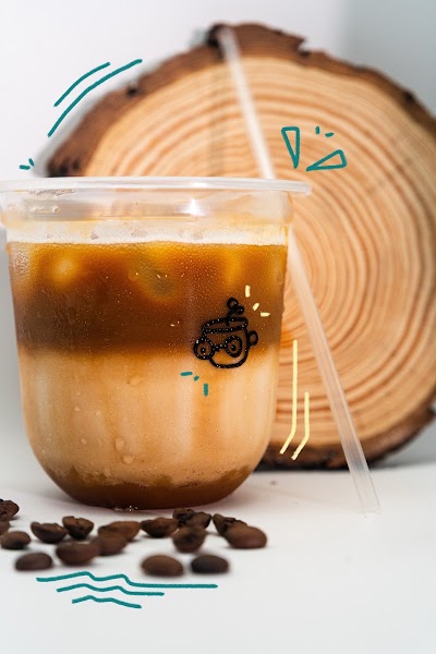 Iced coffee beverage from Weez Coffee served in a clear glass with ice, accompanied by coffee beans and a wooden circular backdrop. — Items: Iced Coffee