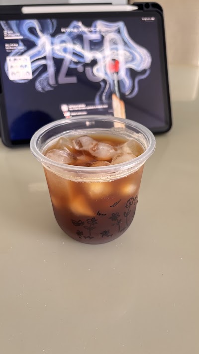 Weez Coffee iced beverage with dark boba pearls in clear cup, served over ice with brown tea-colored liquid. — Items: Iced Coffee with Boba