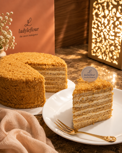 LadyLeFlour multi-layered cake with crumb topping, whole cake displayed with a sliced serving on white plate. — Items: Layered Cake